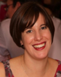 Dr Rachel McMullan, with short dark hair, smiling at the camera