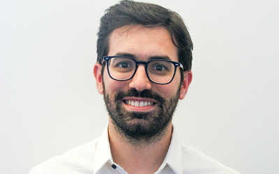 Angelo Salatino, with short, dark hair and a beard, wearing glasses and a white, collared shirt