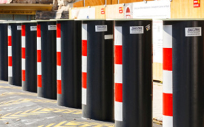 A row of black barriers with red and white stripes down the front of them