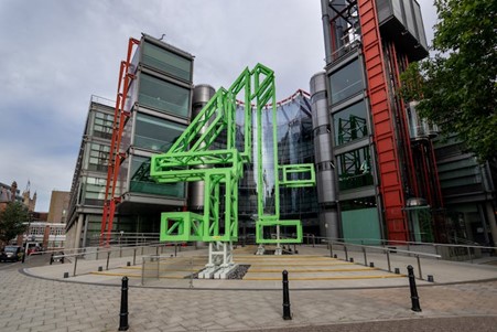 The Channel 4 Building, with a glass-fronted building in the background and a green number 4 structure outside the front of the building