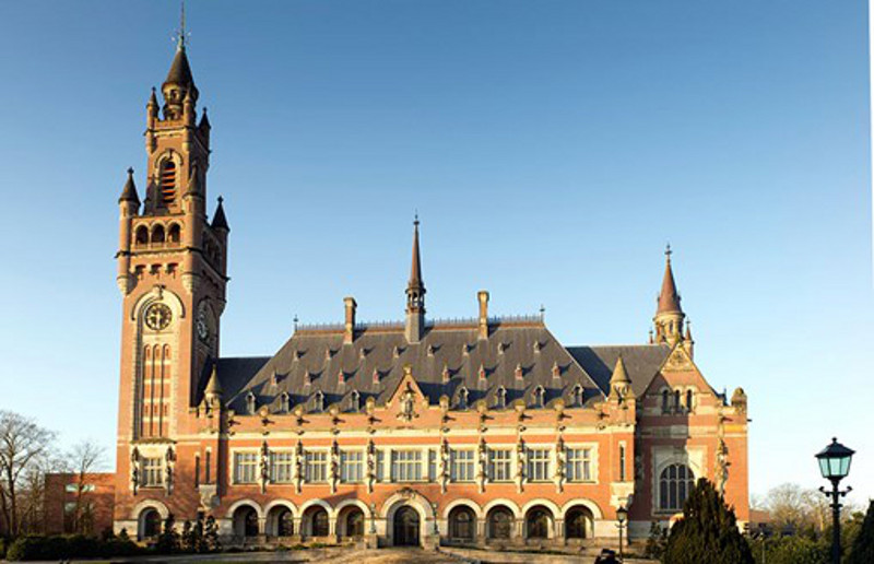 The International Court of Justice in Hague, a building with a tower and one end and arches along the front of the building