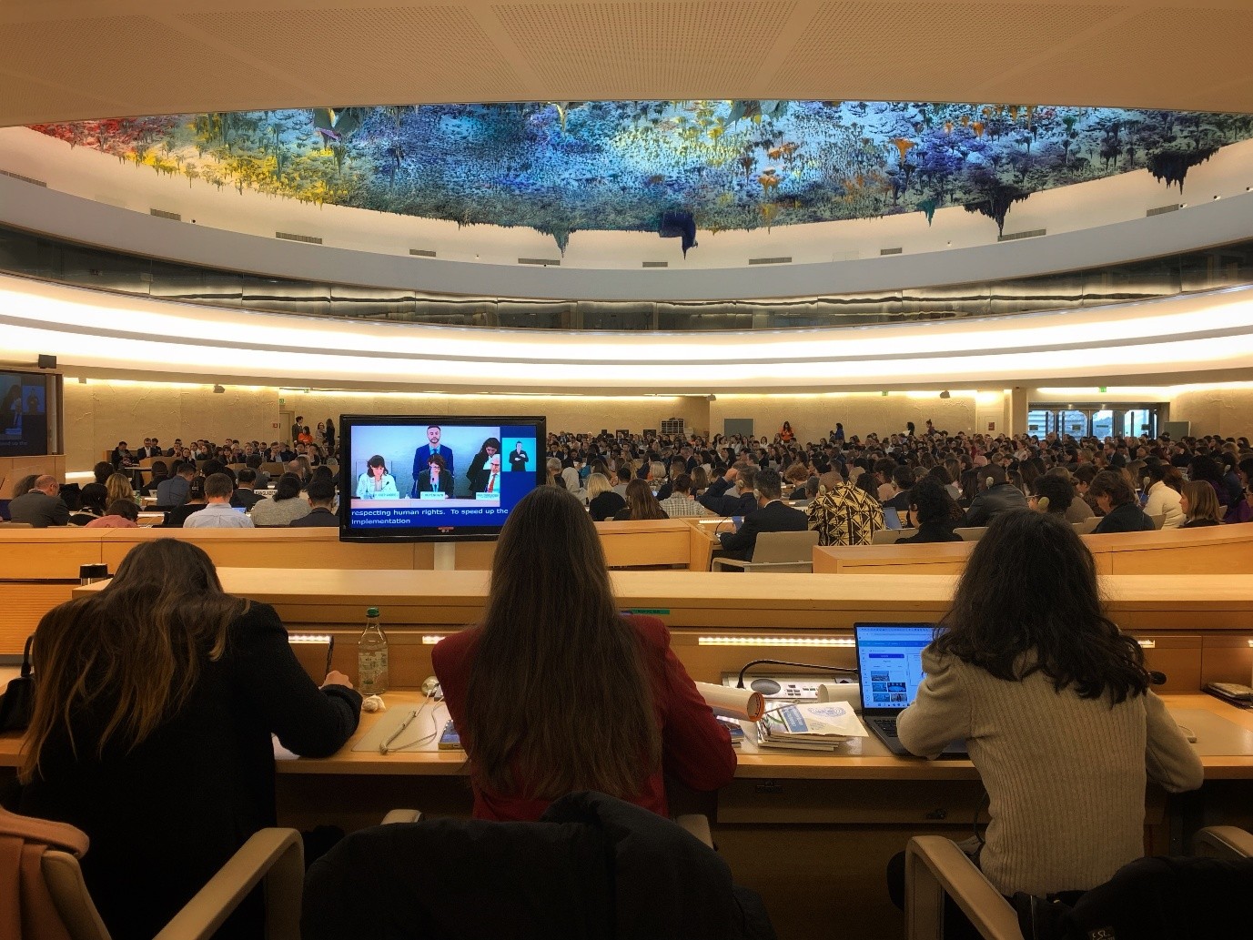 A large group of people sitting at desks with their laptops at a conference