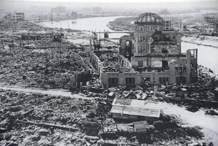 The ruins of buildings after a bomb blast, by the side of a river