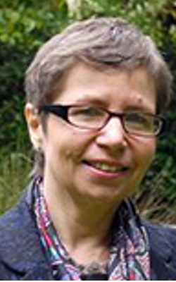 Nicola Martin, wearing glasses and looking at the camera