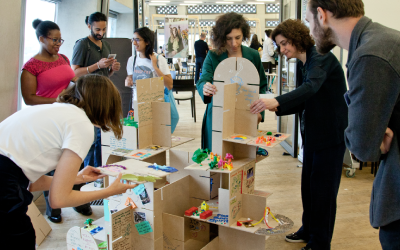 Group of people creating a structure out of cardboard at a workshop