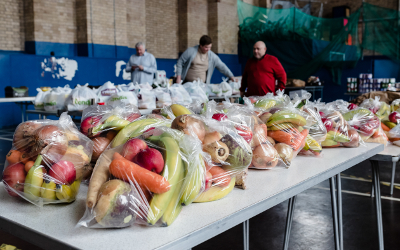 A foodbank, with bags of fruit and vegetables on a table