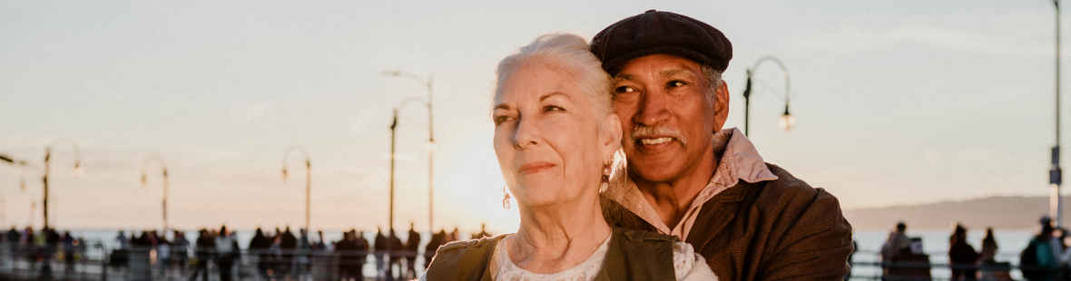 A romantic, elderly couple standing on a pier
