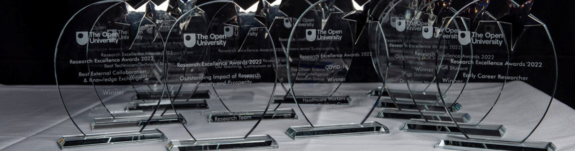 Glass trophies with the OU logo on and the names of the the Research Excellence Awards 2022 categories and winners