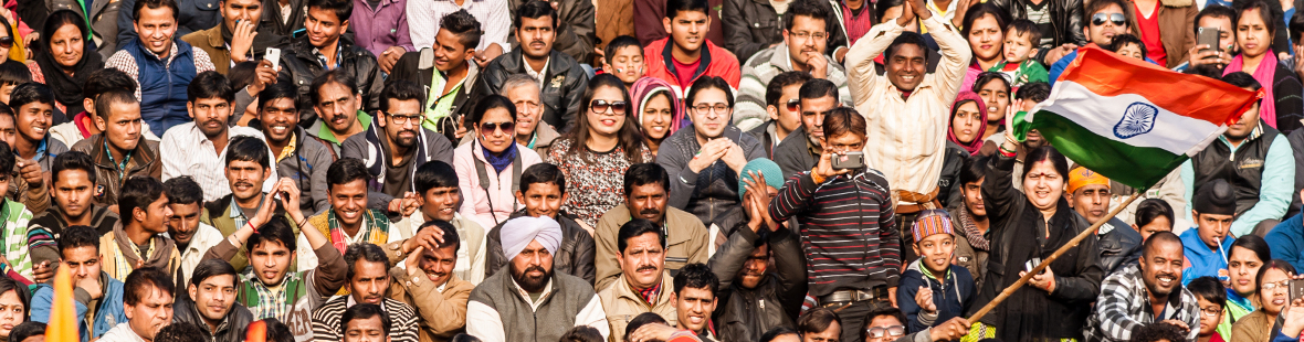 A crowd of Indian people, waving the Indian flag