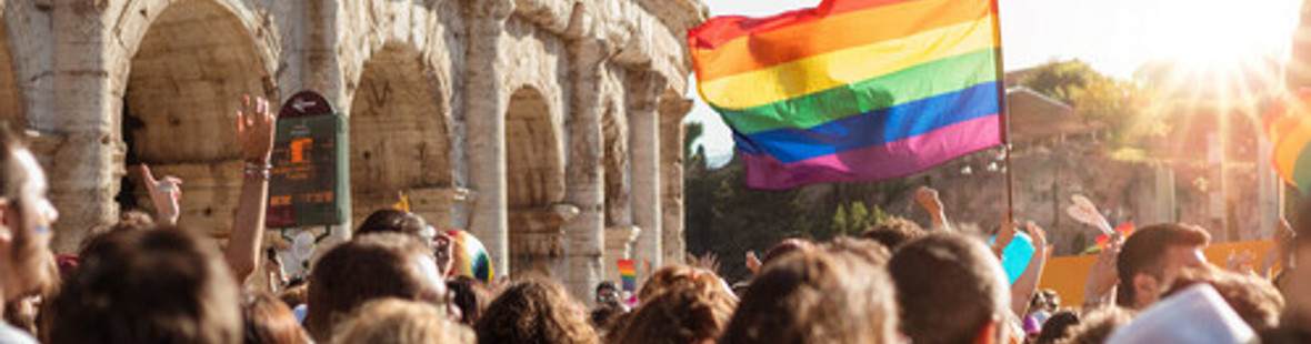 A group of protestors carrying a coloured flag by the Coliseum in Rome