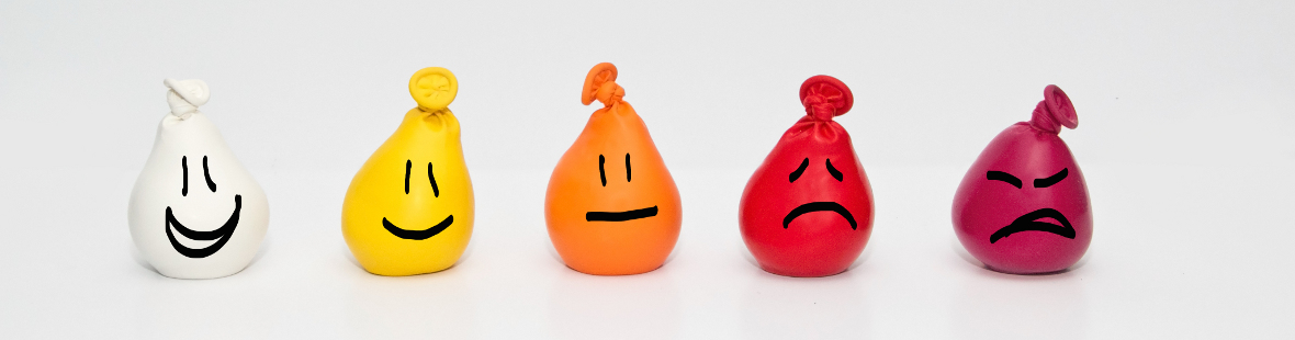 A row of coloured balloons with faces drawn on them