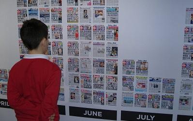 Photo of young boy reading the wall of hateful headlines at the Migration Museum in London (c) Heidi McCafferty