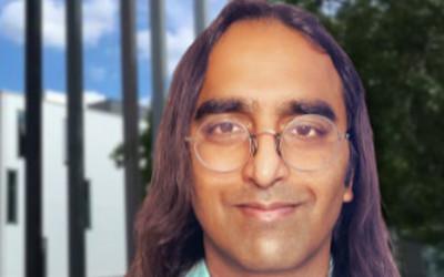 Advaith Siddharthan, with long, dark hair, wearing glasses and a light blue shirt