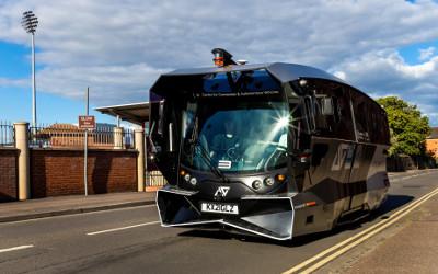 A silver smart bus in a street