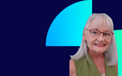 Jaqueline Baxter, with shoulder-length grey hair, wearing glasses and a green top