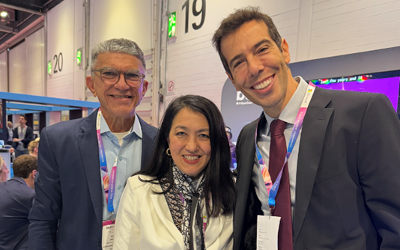 Dr Alexandra Okada, wearing a white jacket and a black and white scarf, standing in between Veveu Arruda and Ronata Feder, who are both wearing dark-coloured suits