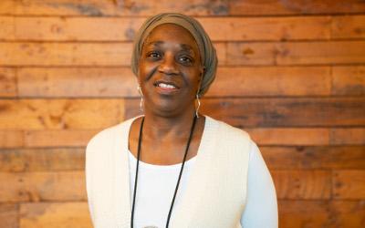 Carol Azumah Dennis, wearing a white top and smiling at the camera