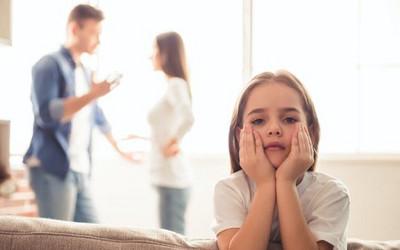 Couple arguing in the background with young girl in the foreground
