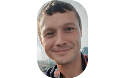 Dr Dan Taylor, with short, dark hair, smiling at the camera