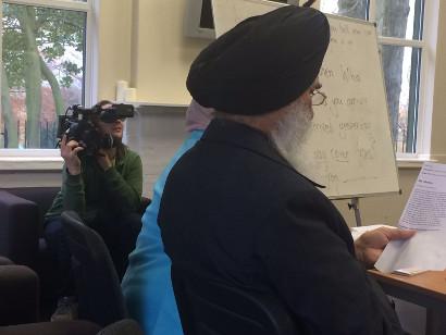 Woman filming a man reading