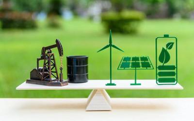 Wooden board with miniature oil rig, plastic leaves and solar panels on it