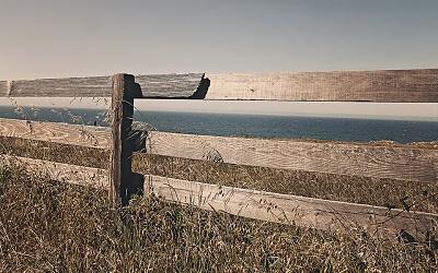 Image of a fence next to the sea representing a country's border