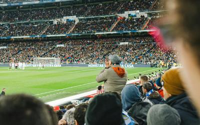 A crowd of people watching a football game in a stadium