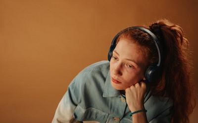 Girl with long, ginger hair wearing headphones