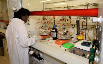Woman wearing a white lab coat working with laboratory equipment
