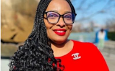 Dr Margaret Ebubedike, with long dark hair, waring glasses and a red top