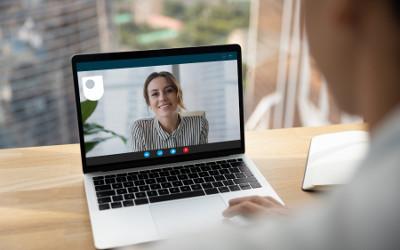 A woman sitting at a desk on a video call with another woman on her laptop
