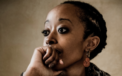 Head shot of Olivia Umurerwa Rutazibwa, with her chin resting on her hand and her eyes gazing into the distance