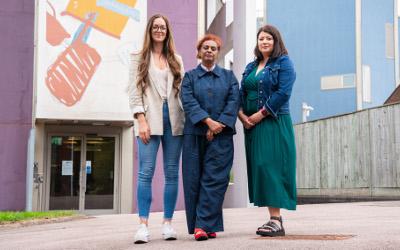 Professor Kesi Mahendran and two female colleagues standing in front of a building