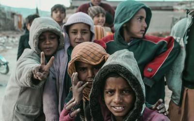 A group of Pakistani children wearing coats with hoods