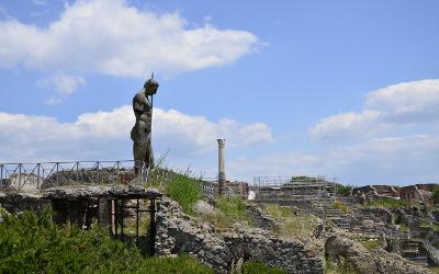 Ruined buildings and statues in Pompeii, covered by grass