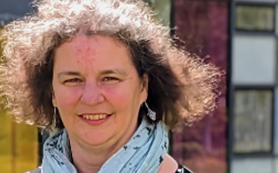 Rachel Hilliam, wearing a blue scarf and smiling and looking at the camera
