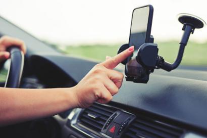 Woman using mobile phone in car