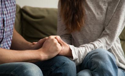 Couple sitting holding hands