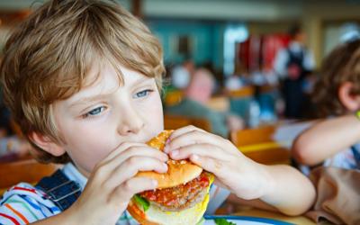 Young boy eating hamburger