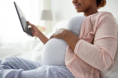 Pregnant woman looking at ipad