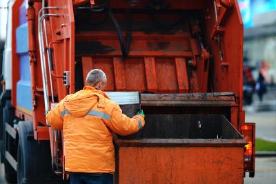 Man loading bin into rubbish truck