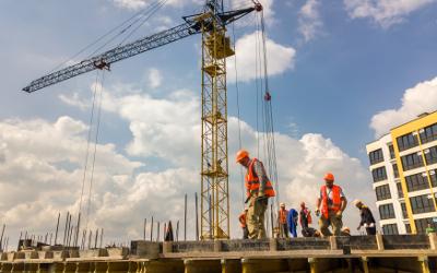Construction workers on a building site with a crane in the background