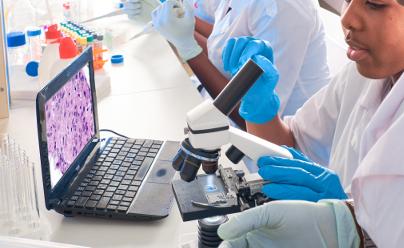 Scientist examning human tissue under a microscope