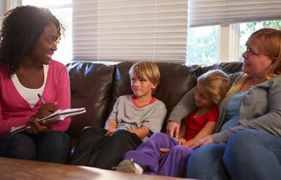 Social worker talking to mother and children