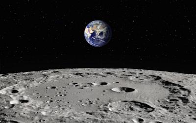 Grey surface of the moon with the Earth in the background