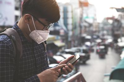 Man with medical mask looking at phone