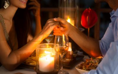 Romantic couple holding hands over a candlelit dinner