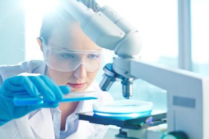 Female researcher using microscope
