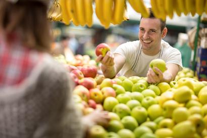Shutterstock-410332369 Man selling apples at a market