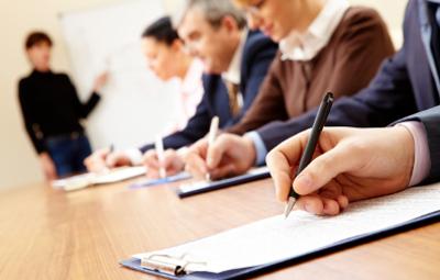 Close up of people writing on a training course